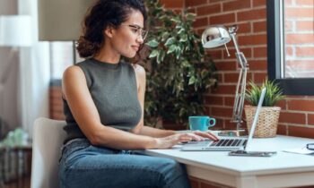 Content creator working from home at a desk and looking out a window for blog post content creation niches