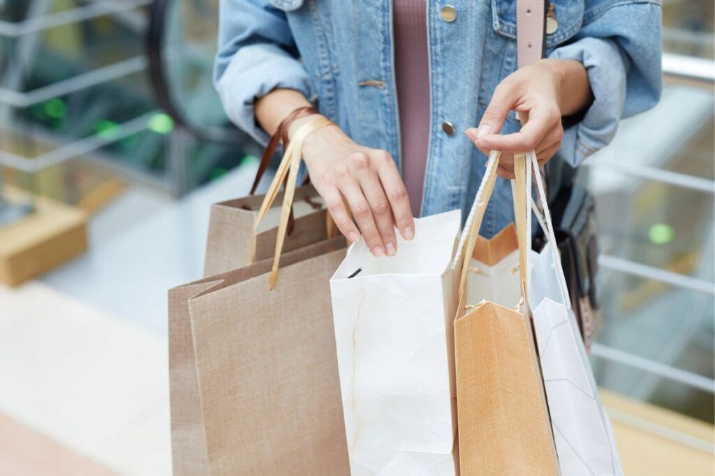 A mystery shopper looking through shopping bags.