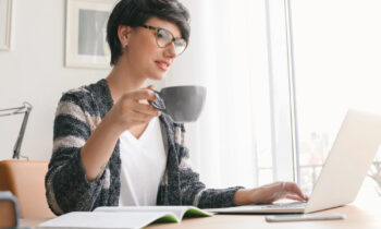 A woman wearing glasses searching for a work from home job with an A+ rating with the BBB