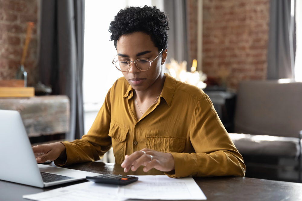 A woman with short hair and glasses working in her home office for 99 career ideas
