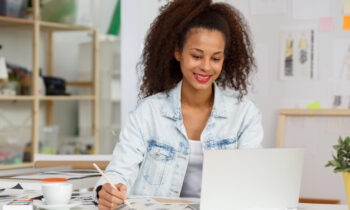A young woman who is looking at her laptop searching for remote staffing jobs