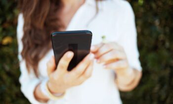 A woman using her smartphone to shop online for blog post how to get free paypal gift cards.