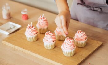 A woman decorating cupcakes in her home bakery.
