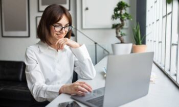 A freelancer working from home, sitting at a desk, using a laptop for find freelance writing jobs