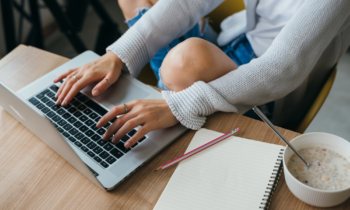 A young woman on her laptop searching for online chat agent jobs